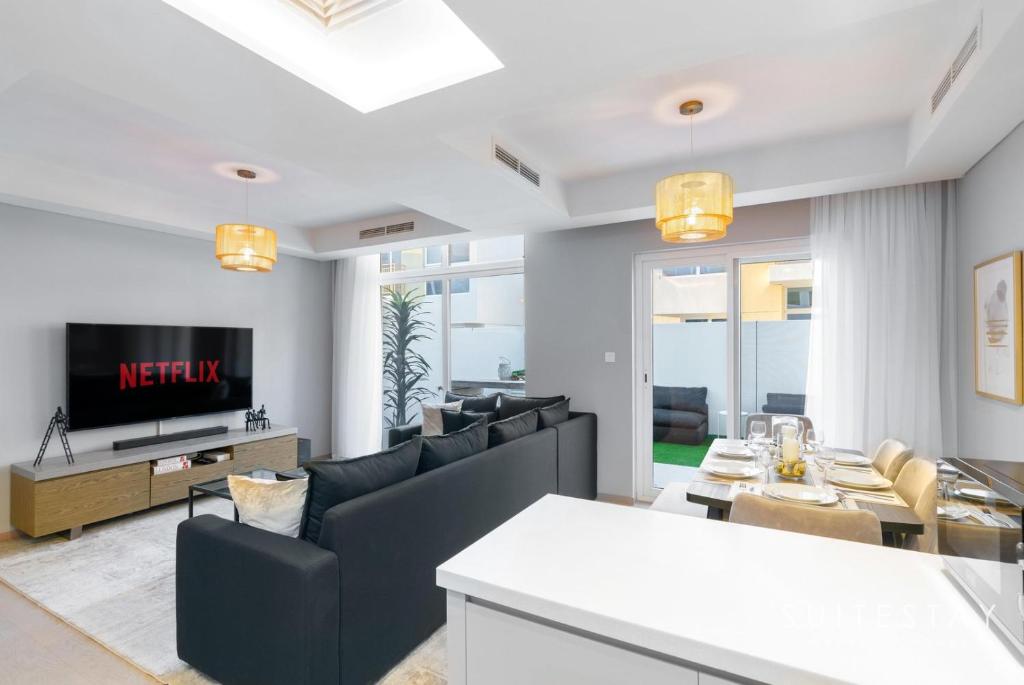 - un salon avec un canapé et une télévision dans l'établissement Adorable Bright Villa in Residential Community, à Dubaï