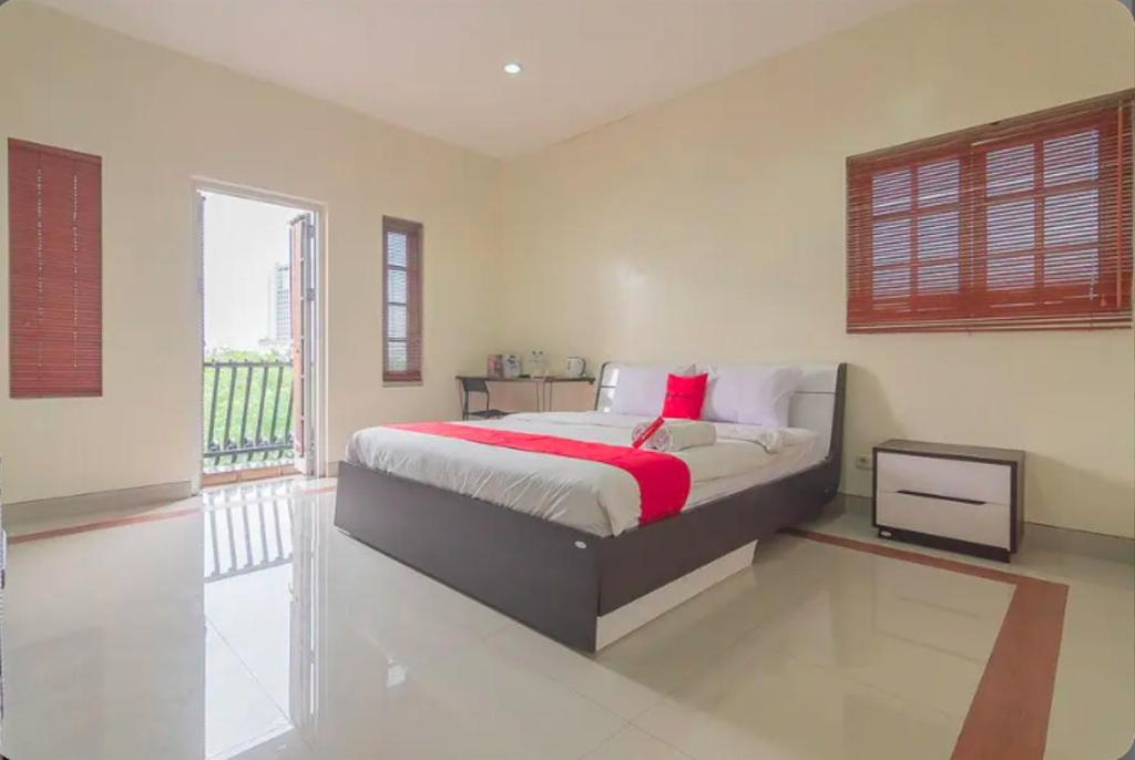 a bedroom with a large bed with a red blanket at RedDoorz @ Malabar Street in Bandung