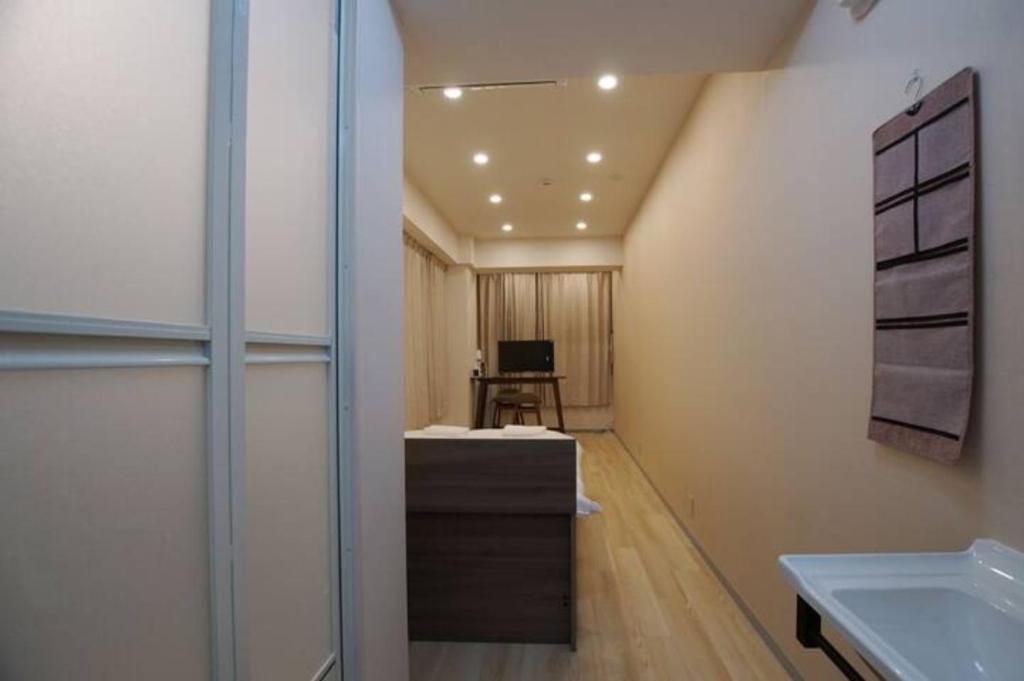 a bathroom with a sink and a desk in a room at Tokyo Guest 浜町 in Tokyo