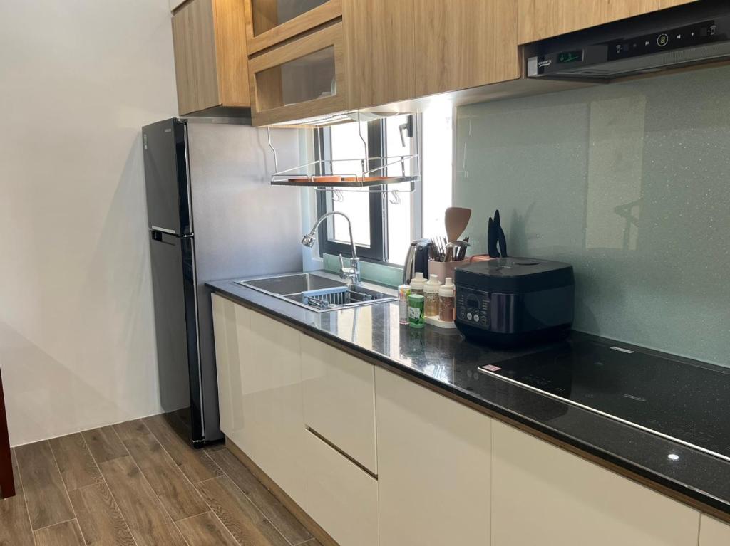 a kitchen with a stainless steel refrigerator and a sink at Residence Á CHÂU in Vung Tau