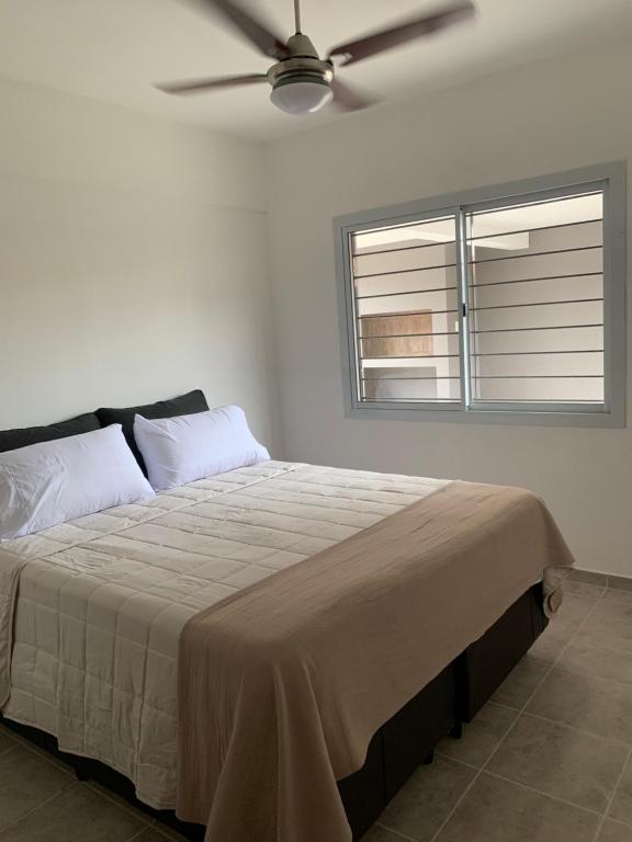 - une chambre avec un lit et un ventilateur de plafond dans l'établissement Housing center, à Jesús María