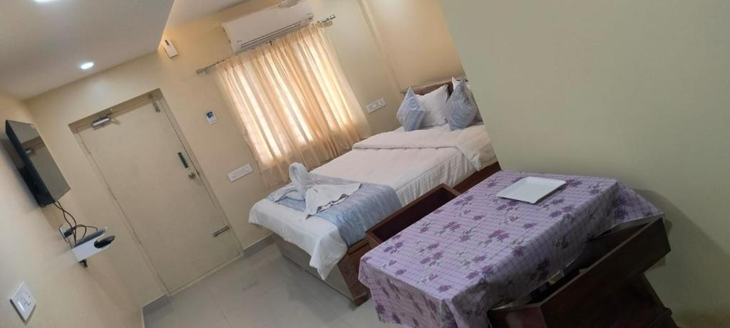 um pequeno quarto com 2 camas e um chuveiro em CORAL STAYS INN em Vijayawāda