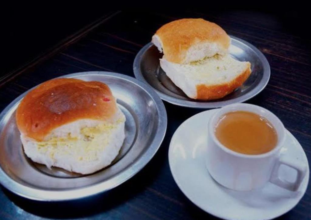 three plates with sandwiches and a cup of coffee at Royal Dormitory in Mumbai