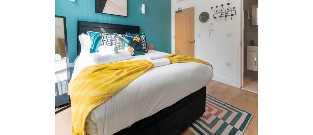 ein Schlafzimmer mit einem großen Bett und einer gelben Decke darauf in der Unterkunft NEW: Bright & Stylish Perfect Studio for 2 in London