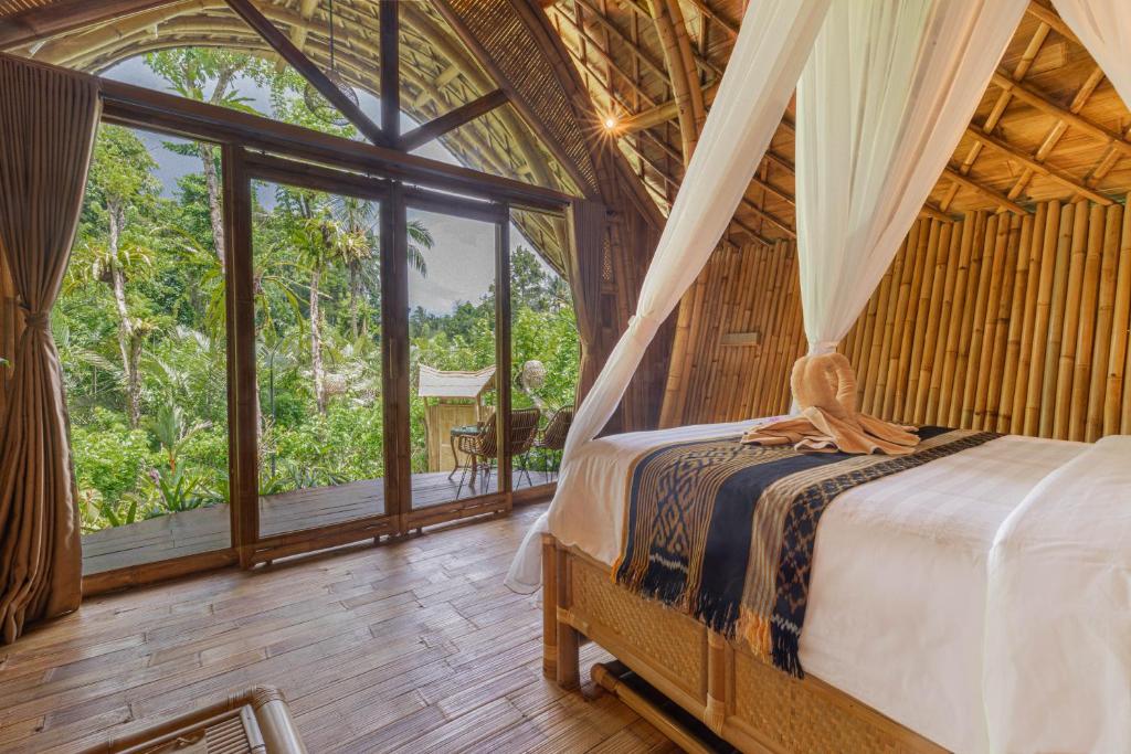 1 dormitorio con 1 cama en una habitación con ventanas en Arcada Bali Bamboo House en Sidemen