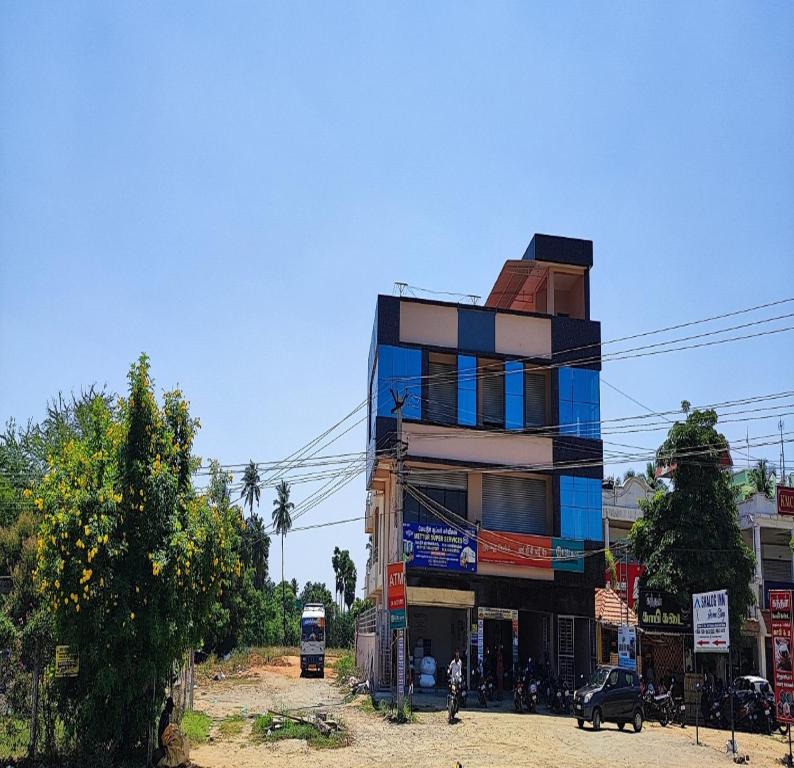 un grand bâtiment sur le côté d'une rue dans l'établissement Shalog Inn Homestay, à Thirumurugan Poondi