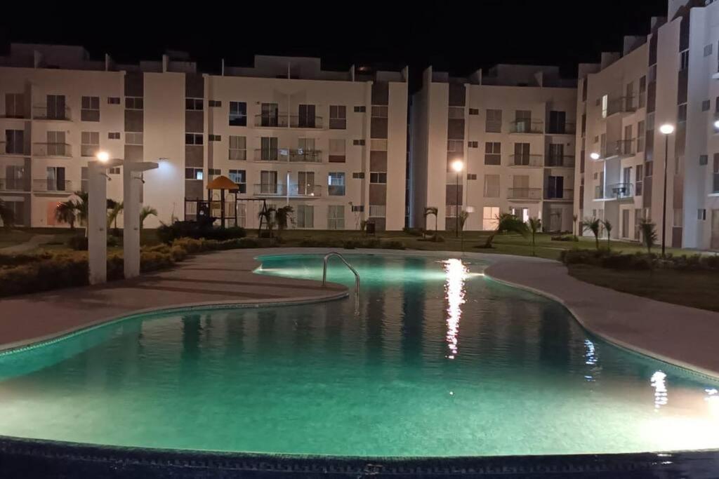 una piscina frente a un edificio por la noche en Apartamento en planta baja en Acapulco