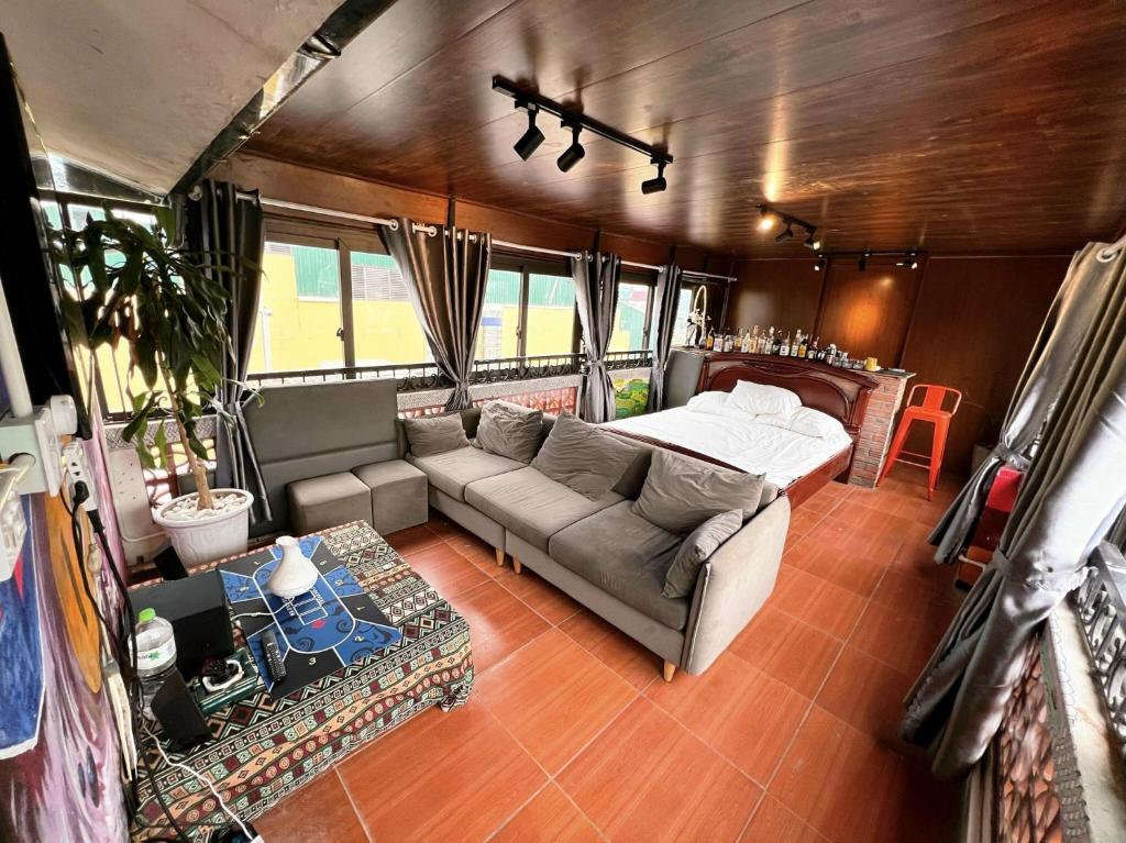 sala de estar con sofá y cama en Ubuntu Hostel - Book Tour Here , Stay Here Free en Hanói