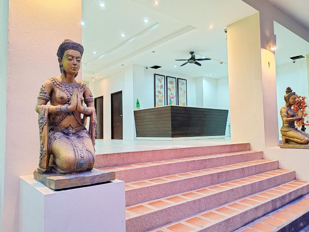 a statue of a woman sitting on the steps of a building at Harmony Patong Hotel in Patong Beach