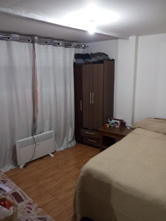 1 dormitorio con 1 cama, vestidor y armario en HuillcaNina, en Urubamba