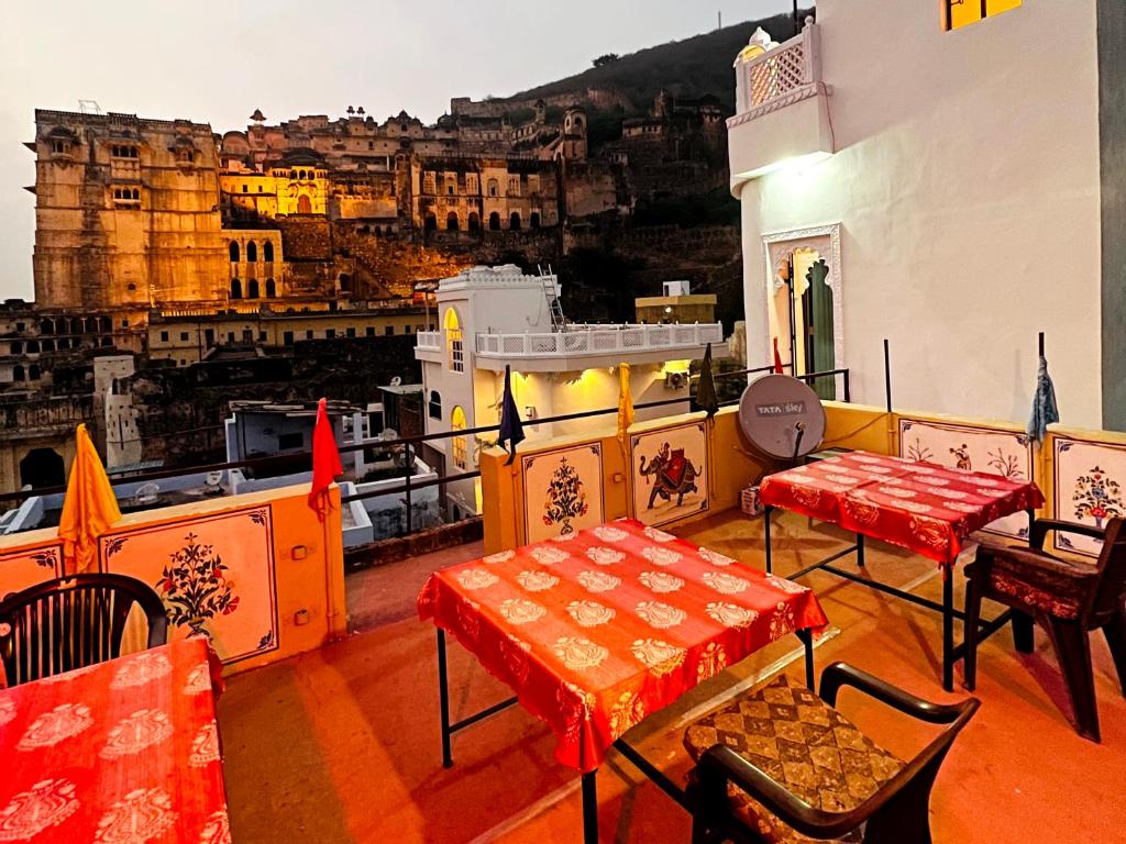 a balcony with tables and chairs and a view of a city at The Palace View Homestay & Restaurant in Būndi