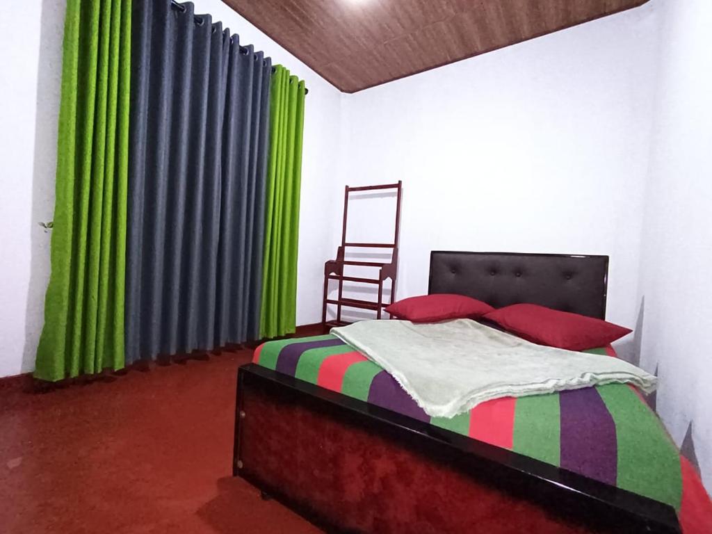 a bedroom with a bed with green curtains and a chair at Green Villa in Nuwara Eliya