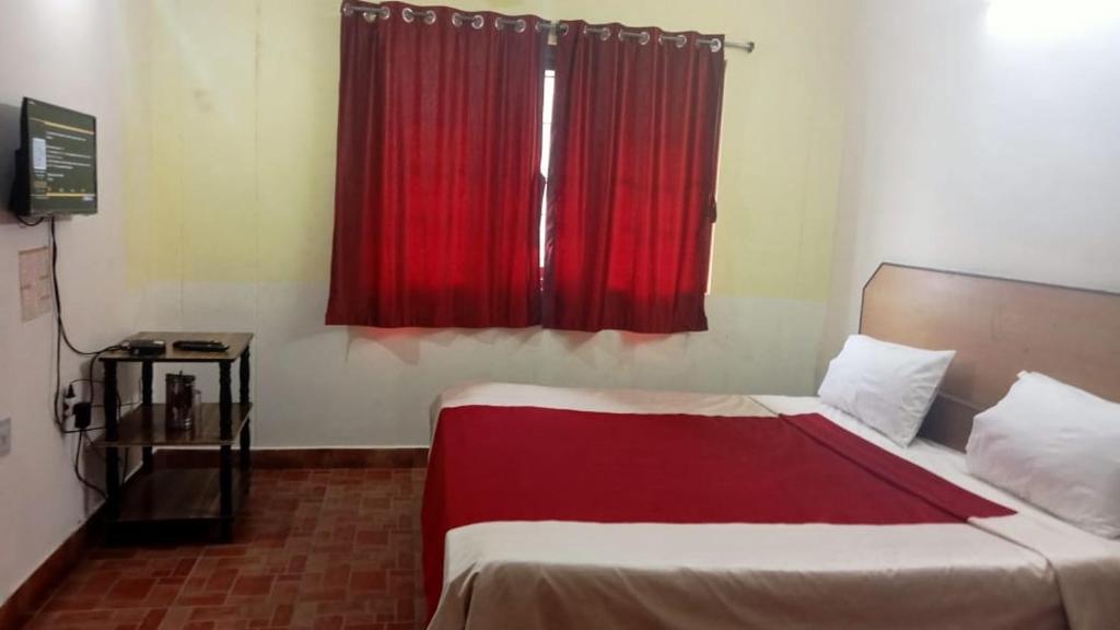 een slaapkamer met een bed en een rood raam bij FLGHR Green Residency in Kodaikānāl