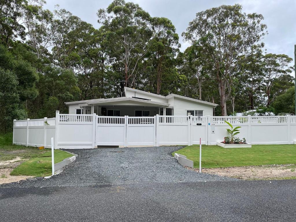 una cerca blanca frente a una casa en The Bedside Manor, en Russell Island