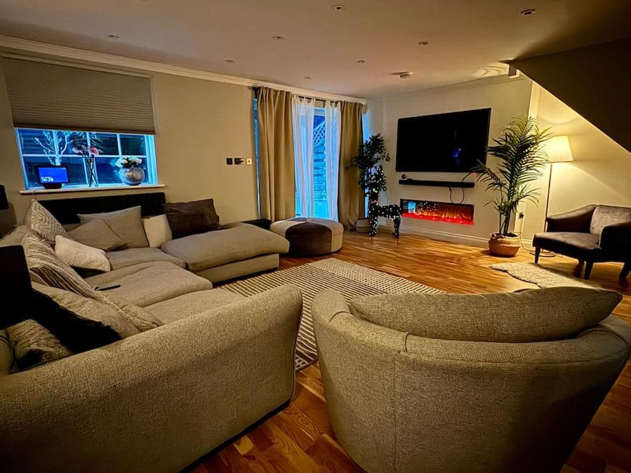 a living room with a couch and a fire place at Entire house with a large lounge in Leverstock Green