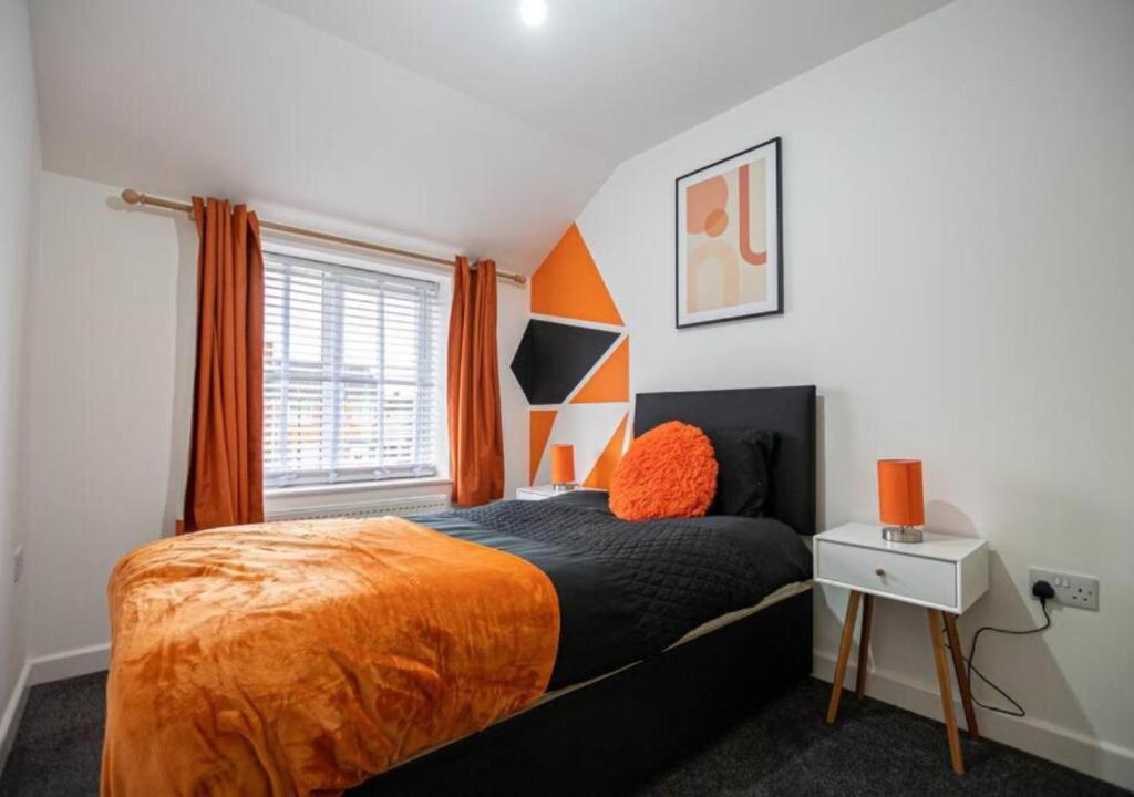 Dormitorio con cama con almohada naranja en 4 Bedroom Apartment with non-smoking room, Free WiFi & Parking - Big monthly price reduction en North Hykeham