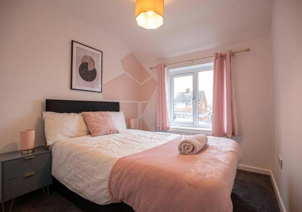 a bedroom with a large bed and a window at 4 Bedroom Apartment - Huge cut price on long stays in North Hykeham