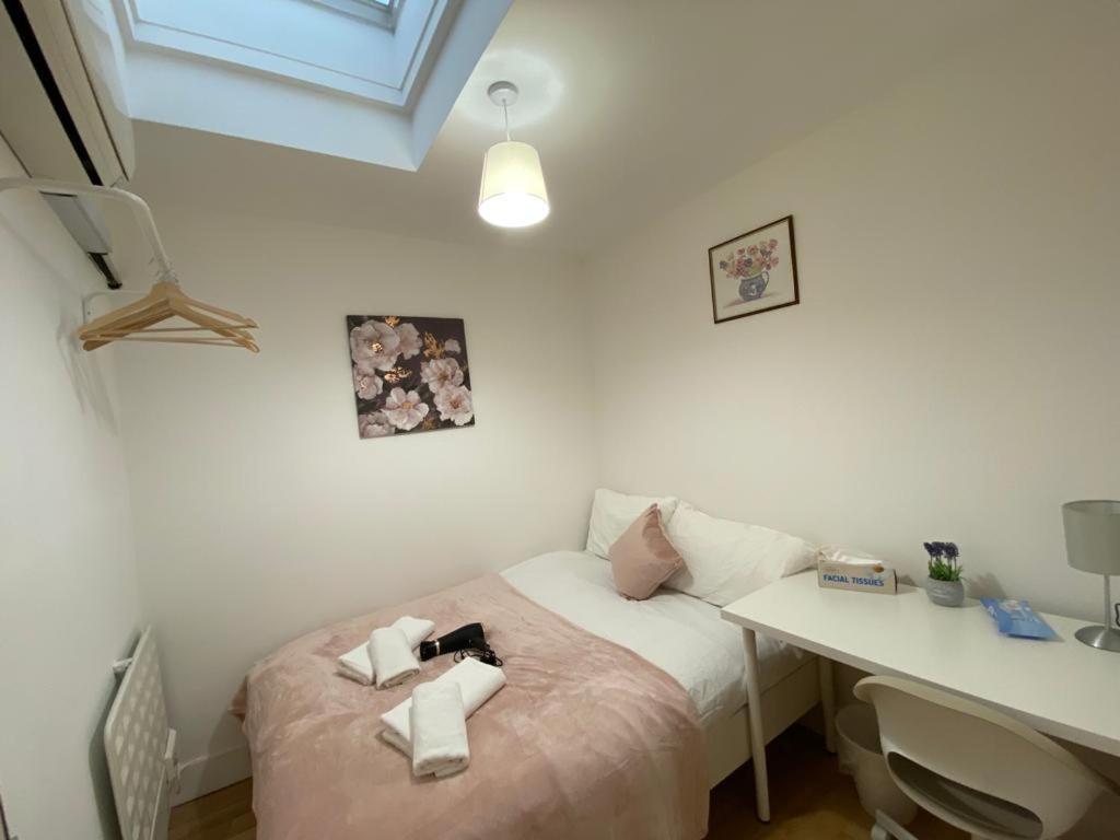 a small bedroom with a bed and a desk at Cosy Private Rooms near Euston Station, Central London in London