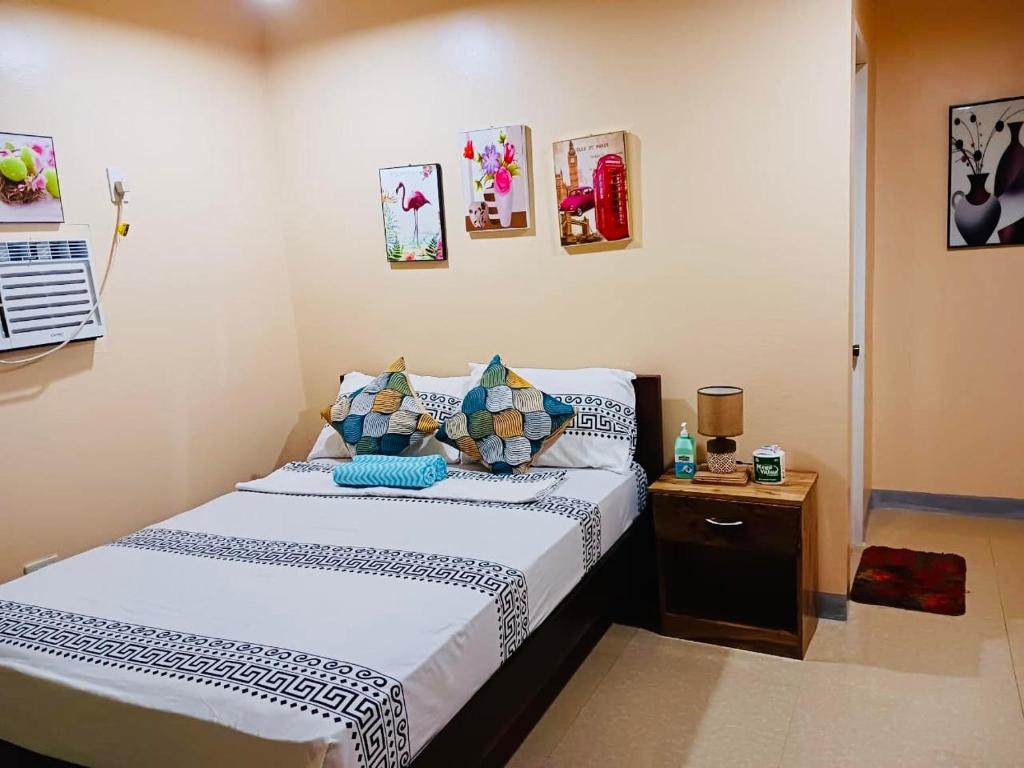 a small bedroom with a bed and a night stand at INDINO GUEST HOUSE 2 in Moalboal
