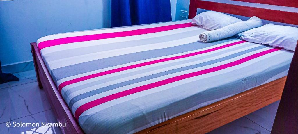 ein Bett mit einer bunten gestreiften Decke drauf in der Unterkunft 2 bedroom Duplex at Kisimani Heights Apartments, Nyali, Mombasa in Mombasa