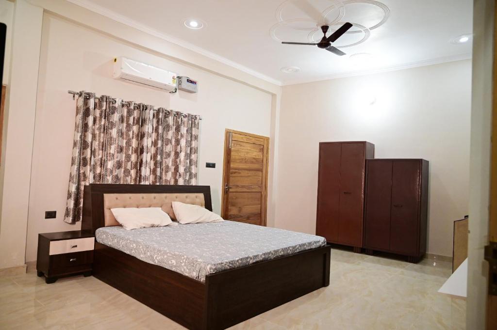 a bedroom with a bed and a ceiling fan at Surendra Villa in Ayodhya