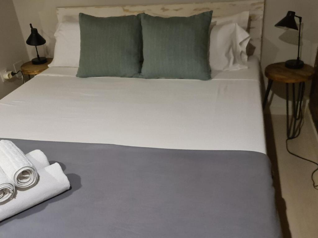 - un grand lit blanc avec deux oreillers et une serviette dans l'établissement Bda plaja, à Badalona