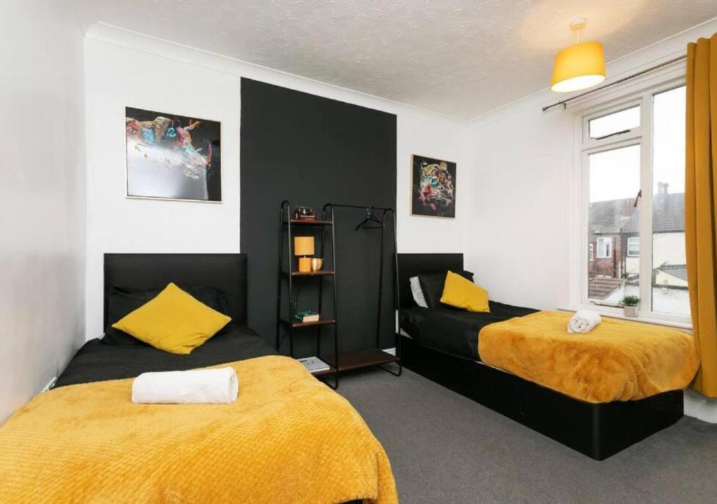 1 dormitorio con 2 camas de color amarillo y negro en 3 Bedroom Apartment - Big special offer for long stays, en Lincolnshire