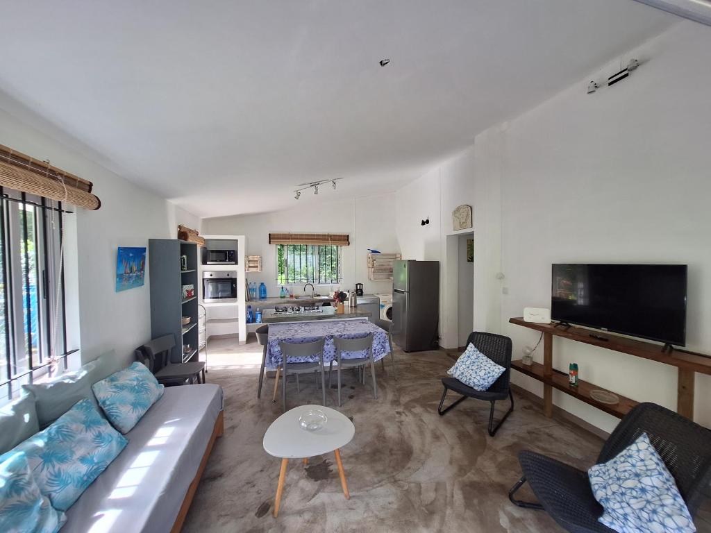 un salon avec un canapé et une table dans l'établissement Maison Tamarin - Riviere Noire pour 5 personnes, à Rivière Noire