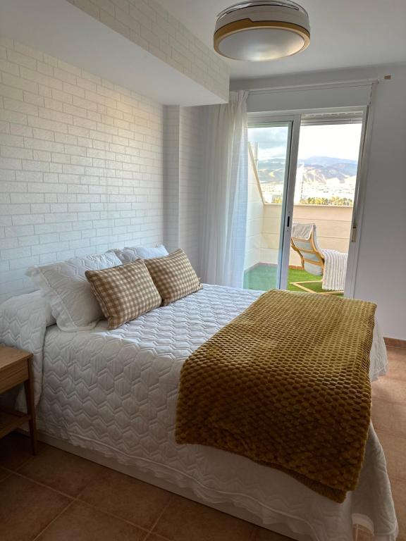 1 dormitorio con cama y ventana grande en Ático SALINAS de Mar, en Roquetas de Mar