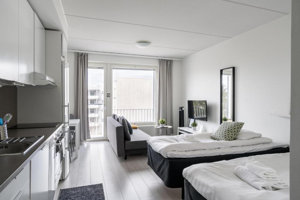 a hotel room with two beds and a kitchen at Hiisi Homes Espoo Center in Espoo
