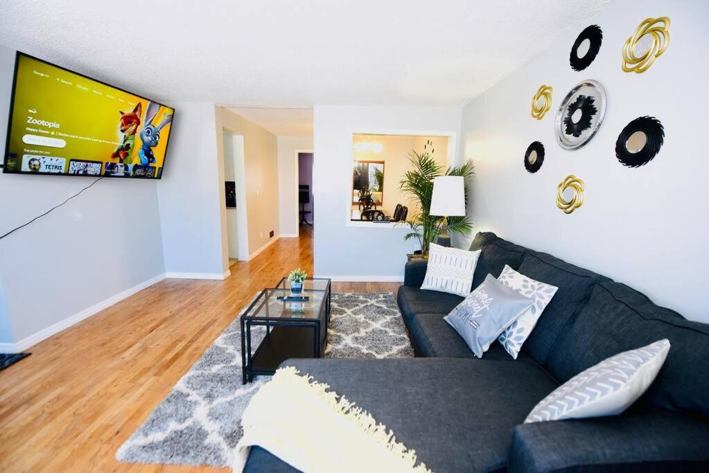 sala de estar con sofá negro y TV en Spacious perfect 2BR in prime location, en Kingston