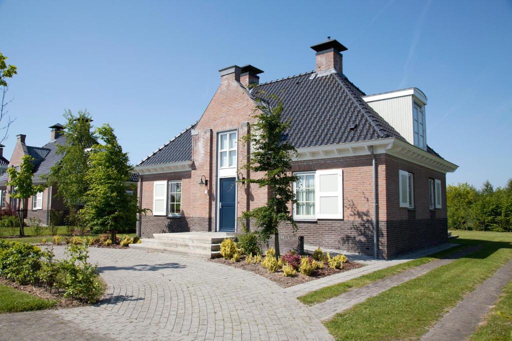 a brick house with a driveway at Summio Buitenplaats De Hildenberg in Appelscha