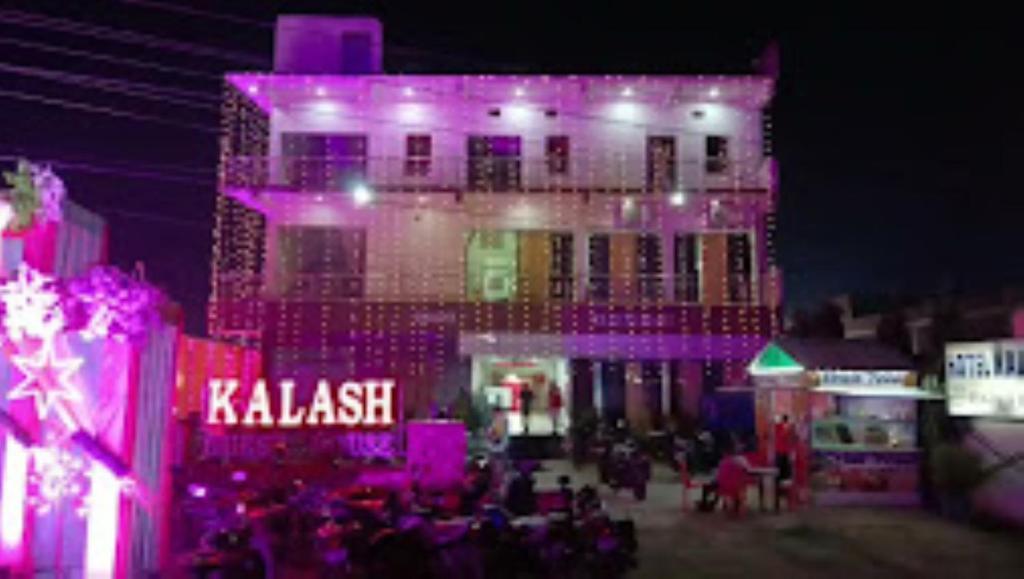 un edificio con luces púrpuras en el lateral. en HOTEL KALASH GUEST HOUSE AND RESTAURANT Kushinagar, en Kushinagar