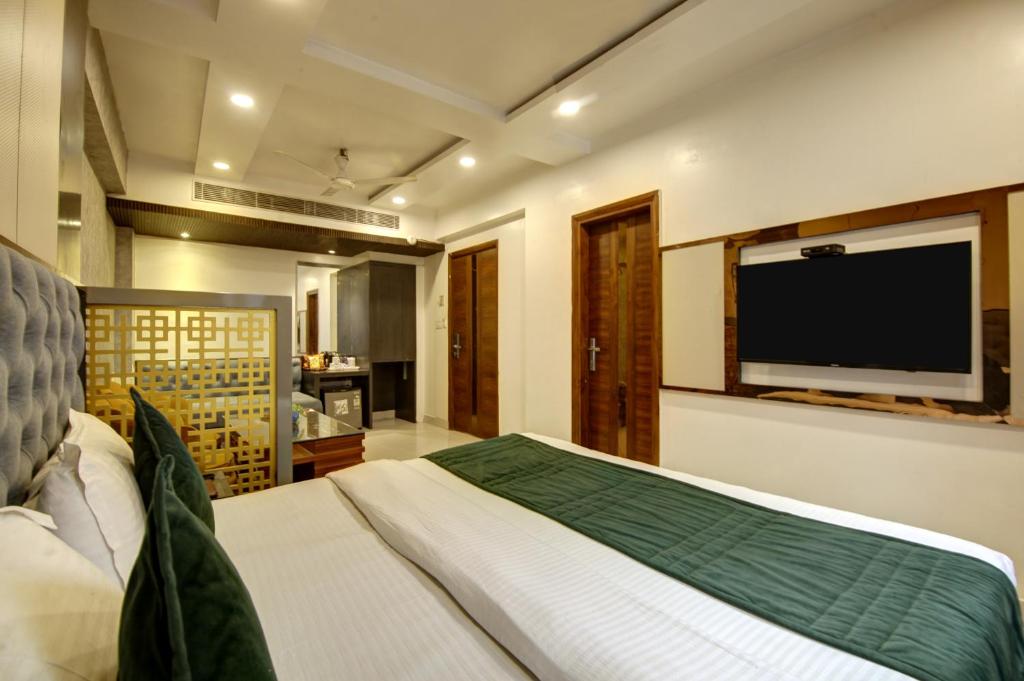 a bedroom with a bed and a flat screen tv at The Shanti Plaza - Traveler's choice awarded 2025 - New Delhi Railway Station, Paharganj in New Delhi