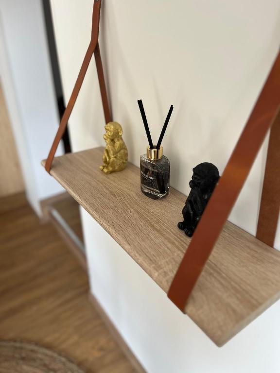 une étagère avec deux figurines assises sur elle dans l'établissement Le petit gîte de la Gare, à Mussidan