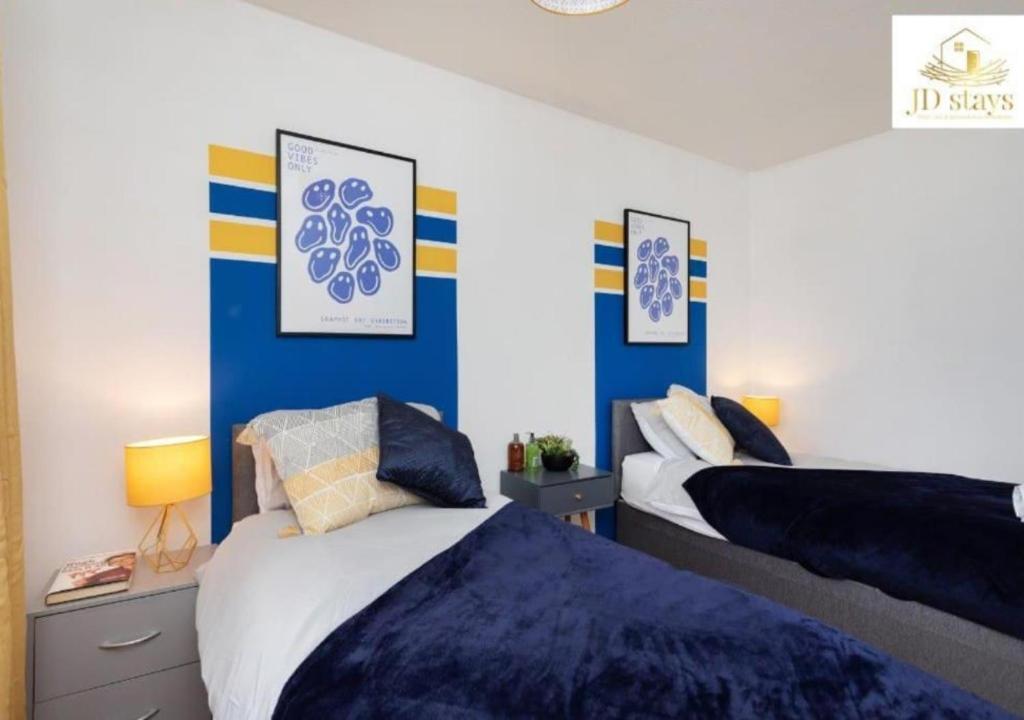 a bedroom with two beds with blue and white walls at 3 Bedroom Apartment with non-smoking room, good location, free Wi-Fi & Parking in Lincolnshire