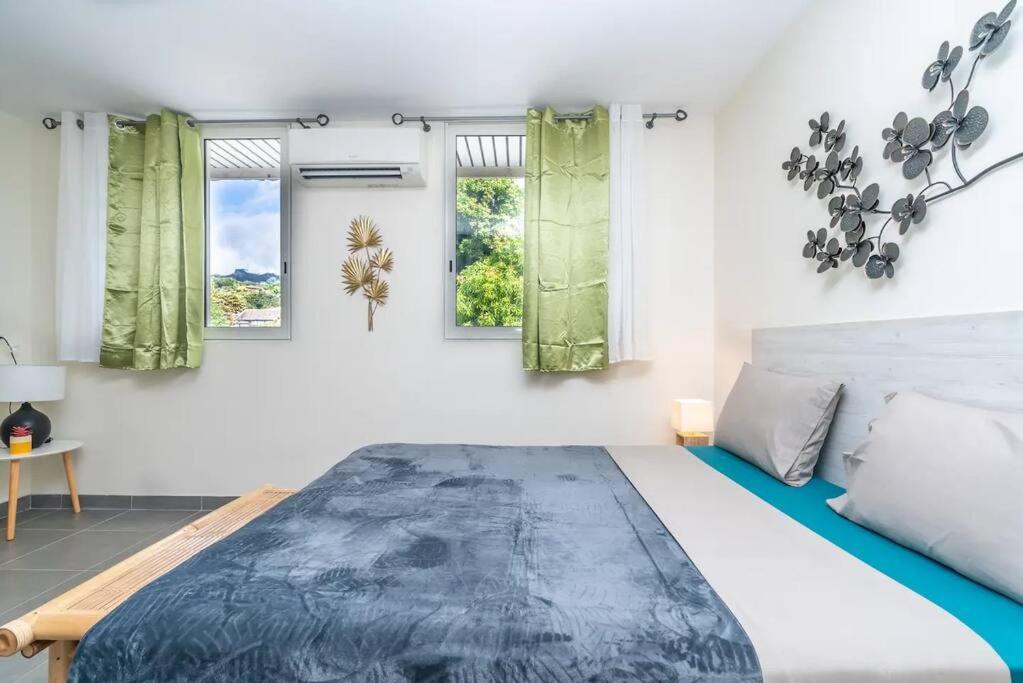 1 dormitorio con 1 cama grande y 2 ventanas en HEITEA LODGE - 6 min airport, Wifi, AC & Parking en Papeete