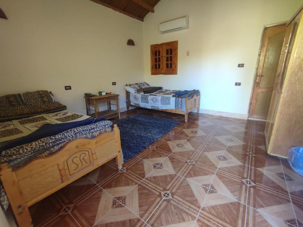Zimmer mit 2 Betten und Fliesenboden in der Unterkunft Sand Rose Bahriya Hotel in Bawati