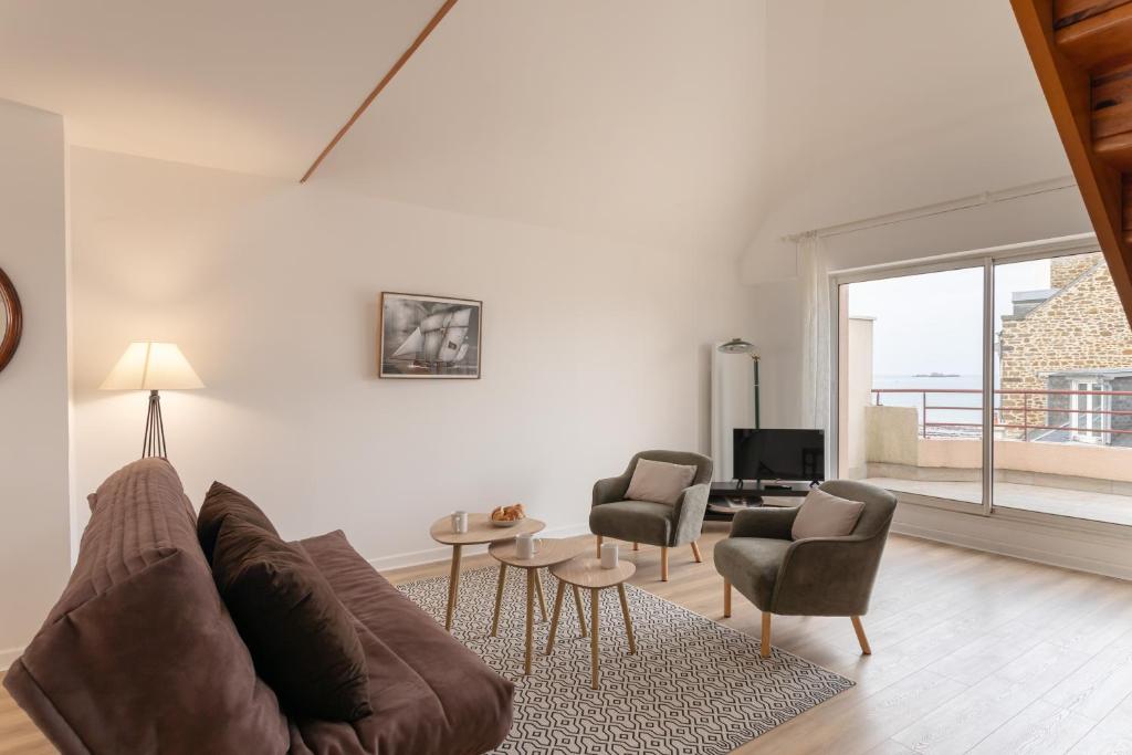un salon avec un canapé et deux chaises dans l'établissement Amatasi - Appt Duplex vue mer, à Saint-Malo