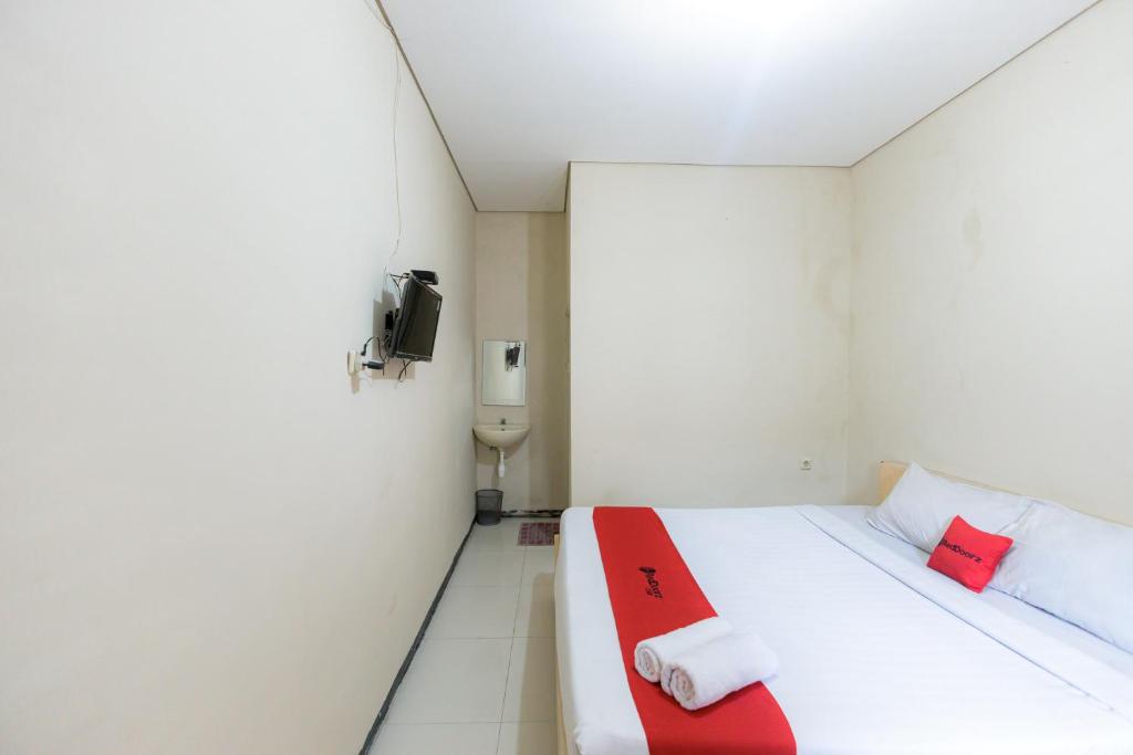 Postel nebo postele na pokoji v ubytování RedDoorz at Osuko Residence Sukomanunggal Jaya