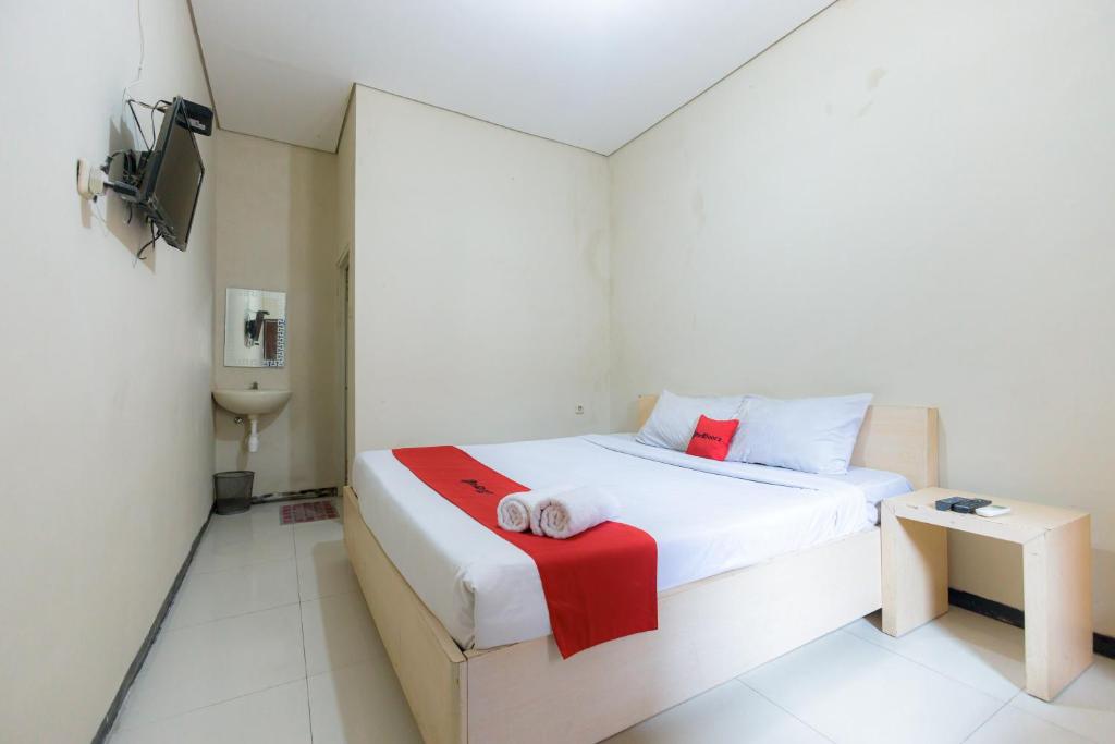 Postel nebo postele na pokoji v ubytování RedDoorz at Osuko Residence Sukomanunggal Jaya