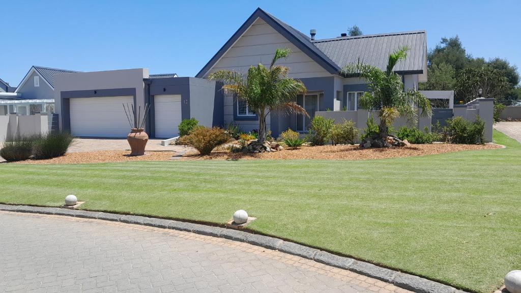 a house with two birds sitting on the grass at Albatross @ Kingswood in George