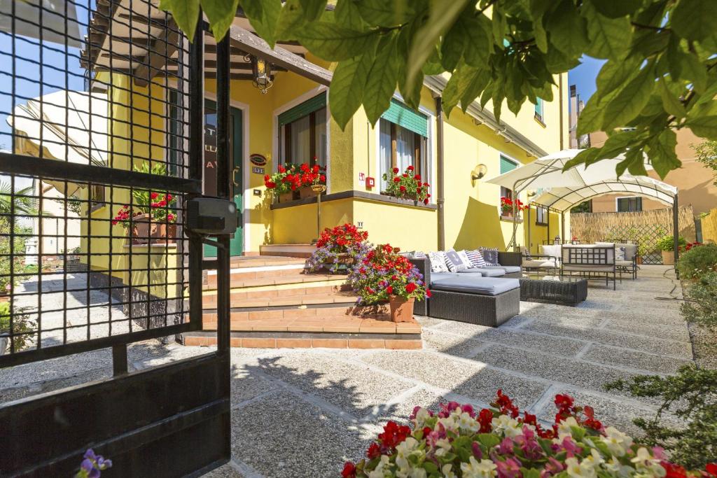 une maison jaune avec des fleurs sur les escaliers dans l'établissement Hotel Villa Tiziana, sur le Lido de Venise