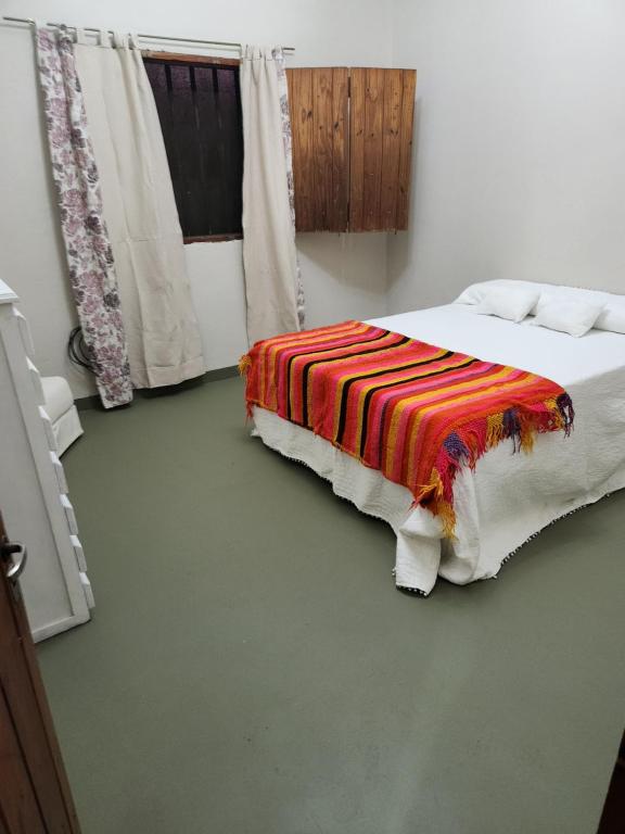Un dormitorio con una cama con una manta de colores. en La finca 