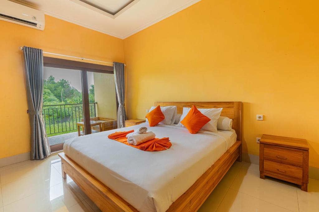 una camera da letto con un letto con pareti arancioni e una finestra di Srinadi Waterpark Villa a Klungkung