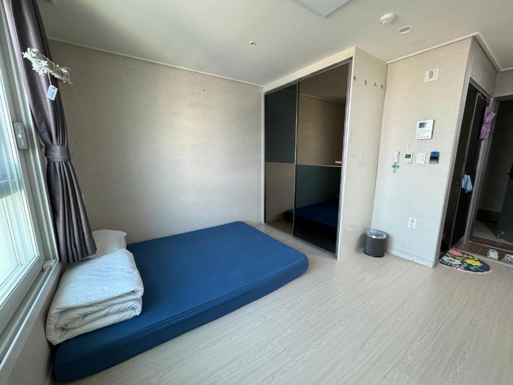 a small room with a blue bed in a room at Sea View Doubleroom in Incheon