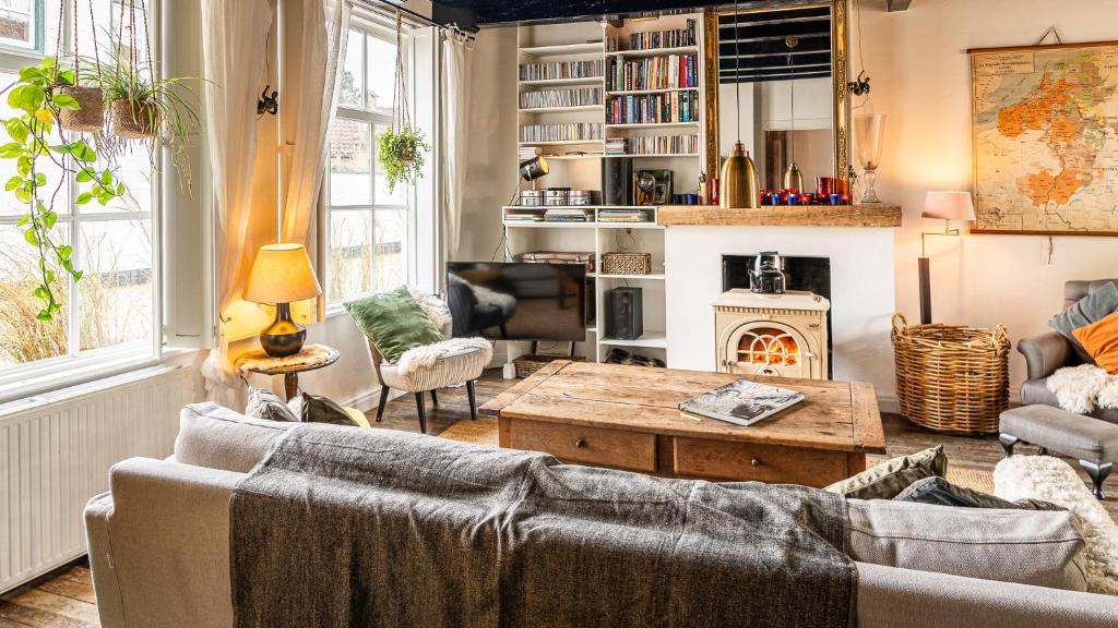 ein Wohnzimmer mit einem Sofa und einem Kamin in der Unterkunft Haven 1 in Sint Anna ter Muiden