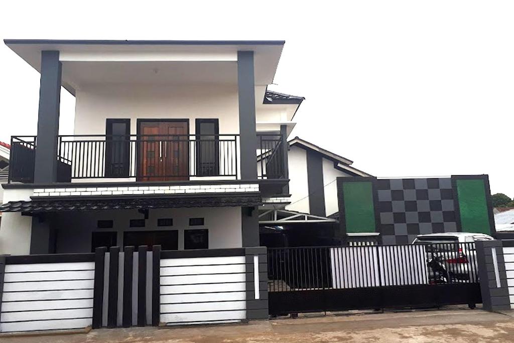 une maison blanche avec une clôture noire et blanche dans l'établissement Pondokan Guest House Rinjani Syariah, à Bengkulu