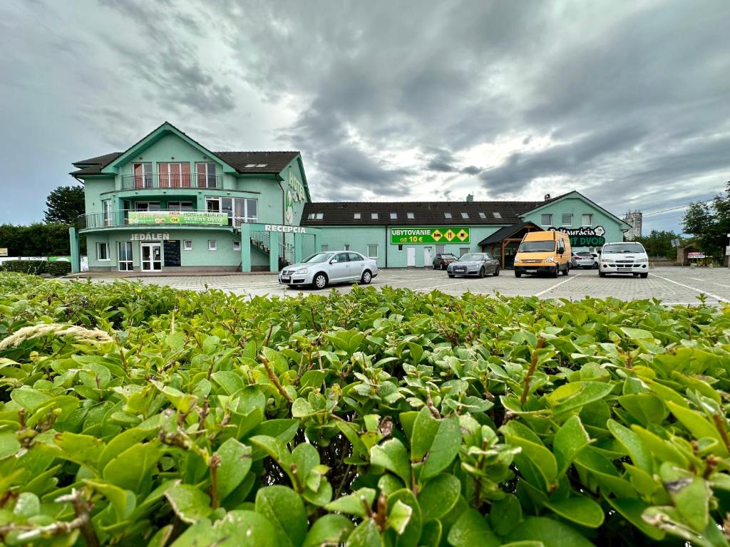 un estacionamiento con autos estacionados frente a un edificio en HOTEL ZELENÝ DVOR, en Senec