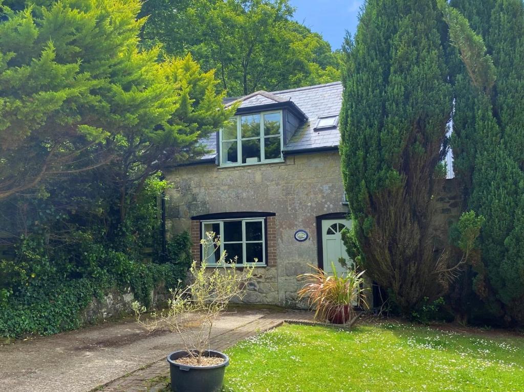 a stone house with a green door and trees at 1 Bed in Godshill IC146 in Godshill